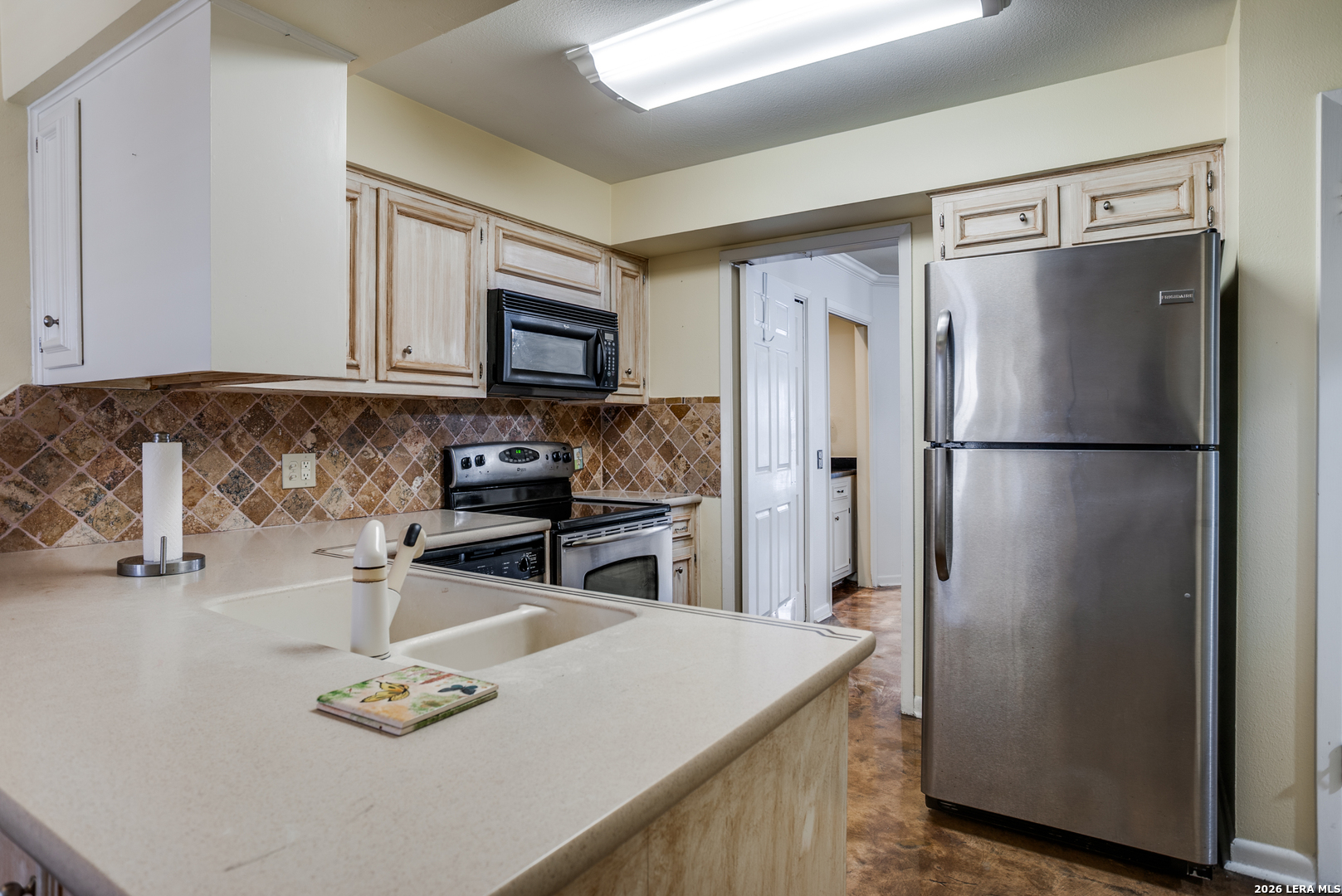 5359 Fredericksburg, Unit 515 San Antonio, TX 78229 - Photo 4 of 25 a kitchen with stainless steel appliances granite countertop a refrigerator a stove and a sink with wooden floor