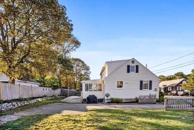 a view of a house with a big yard and large trees