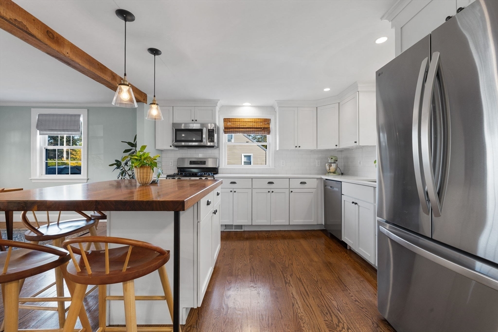 13 Parsons Drive Beverly, MA 01915 - Photo 5 of 31 a kitchen with stainless steel appliances granite countertop a refrigerator a sink dishwasher a stove and white countertops with wooden floor