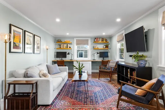 a living room with furniture a rug and a flat screen tv