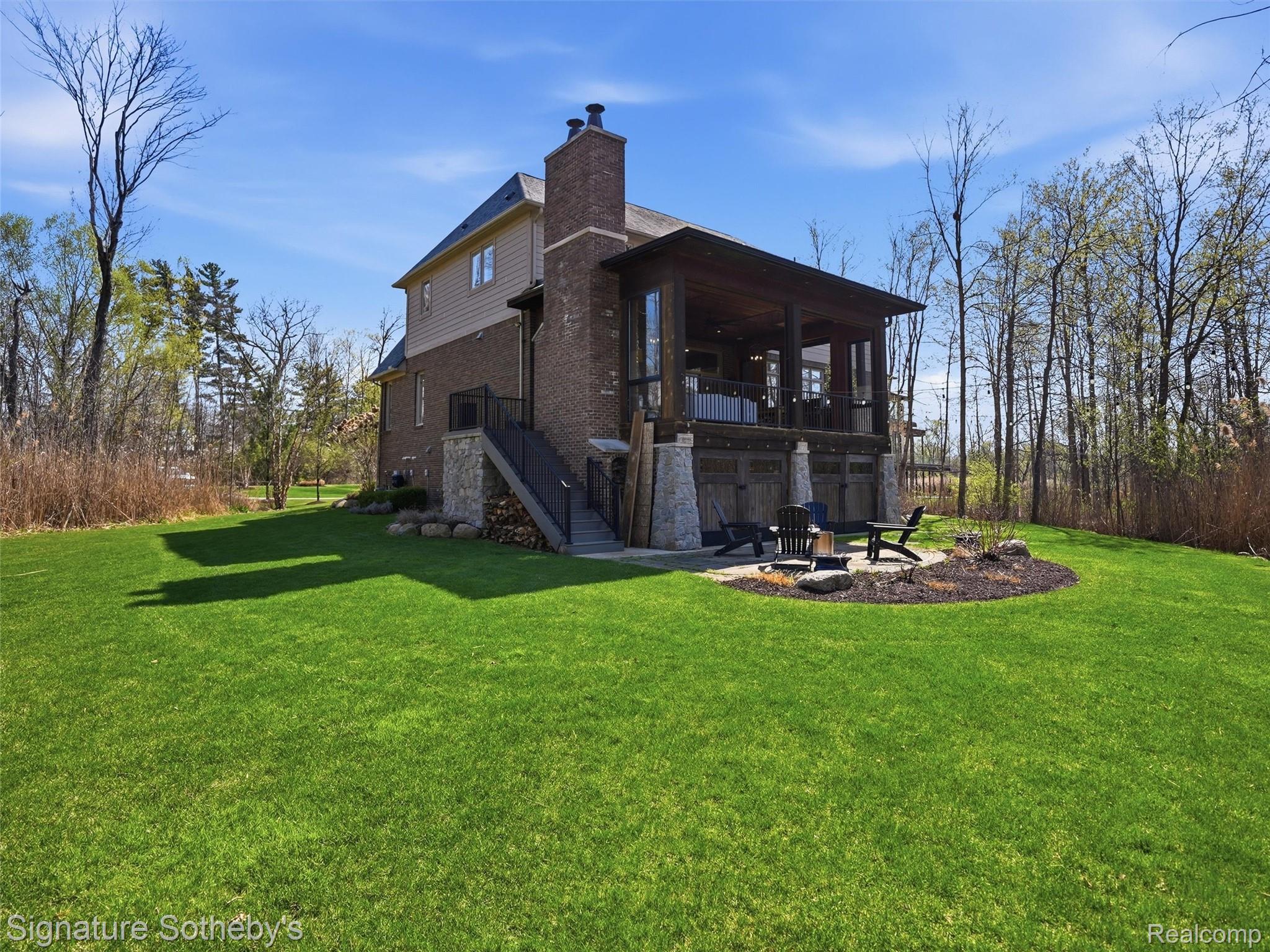 1595 Carriage Way Rochester, MI 48307 - Photo 20 of 78 Rear view of house with a patio area, a yard, a chimney, a fire pit, and brick siding
