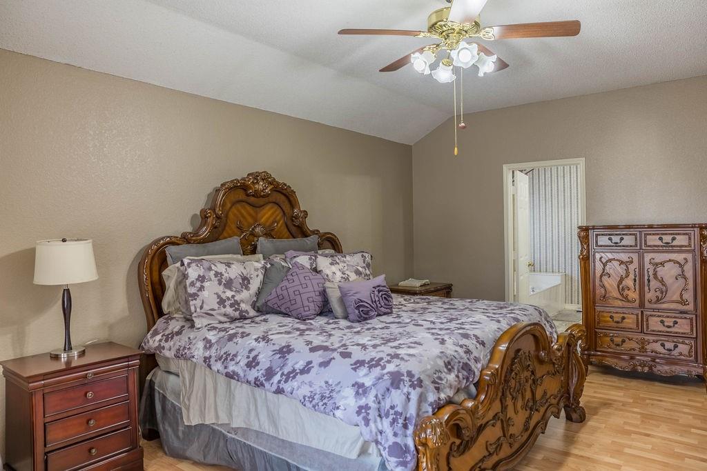 4113 Bluffpoint Road Rowlett, TX 75088 - Photo 18 of 39 a bedroom with a bed and a chandelier