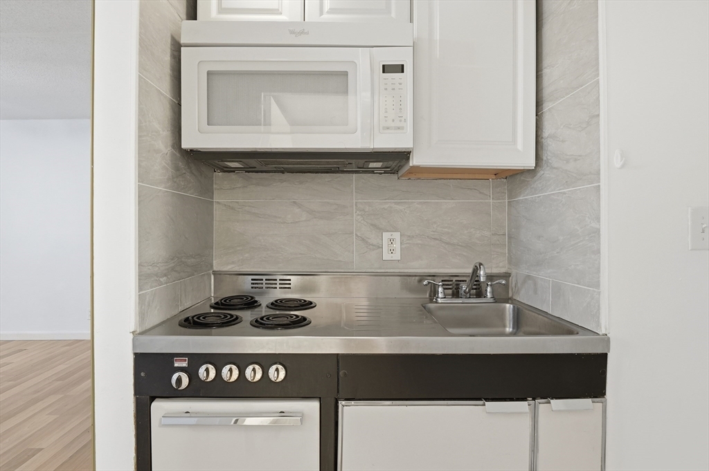 70 Southbridge Street, Unit 310 Worcester, MA 01608 - Photo 5 of 28 a kitchen with a stove and cabinets