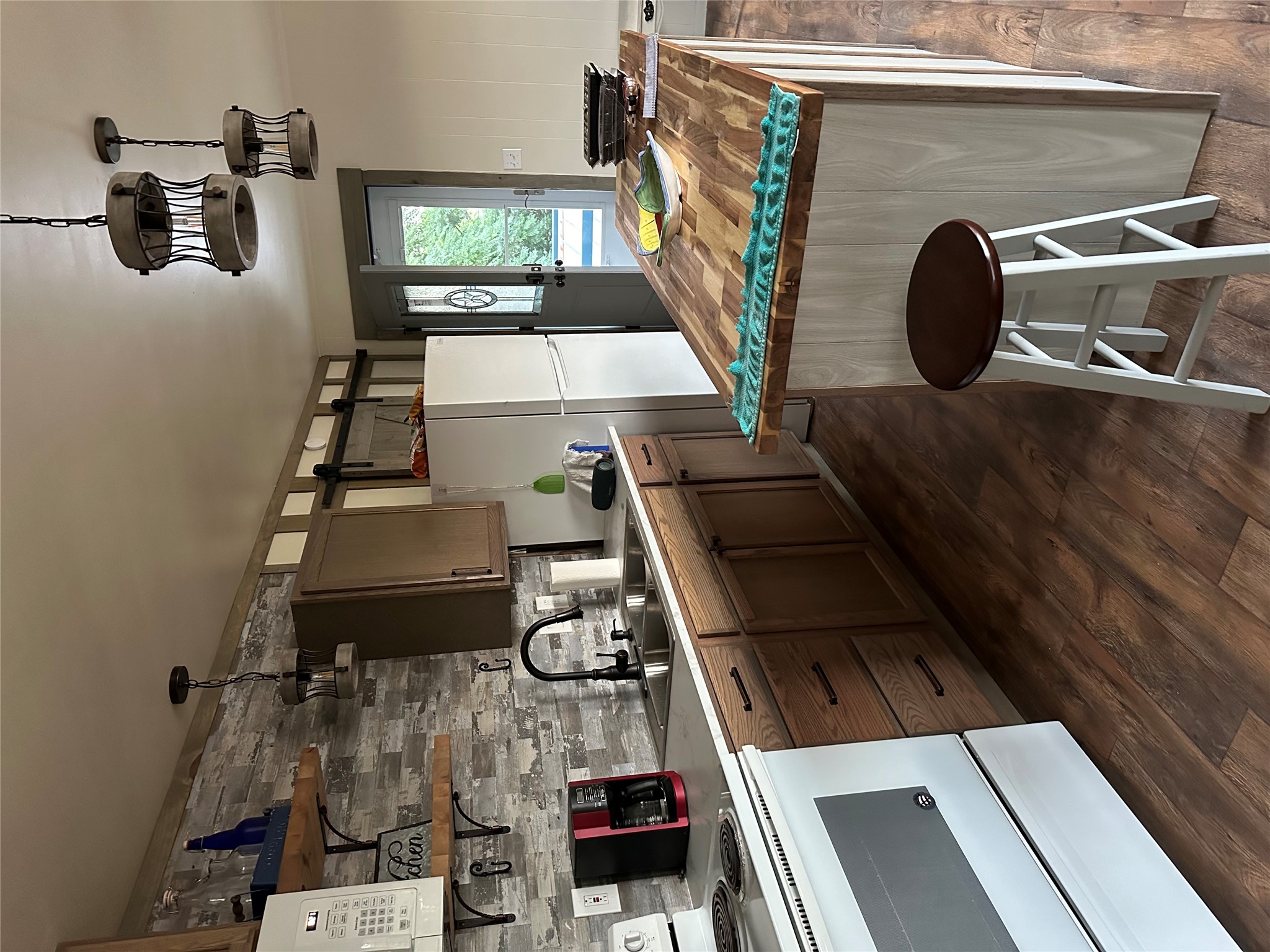 161 A Alexander Drive, Unit 9 Tow, TX 78672 - Photo 1 of 1 Kitchen featuring butcher block countertops, white appliances, hanging light fixtures, a kitchen island, and dark wood finished floors