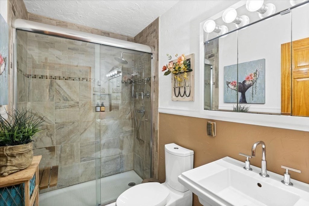 7 Glendale Road Wareham, MA 02558 - Photo 11 of 33 a bathroom with a sink mirror and a shower