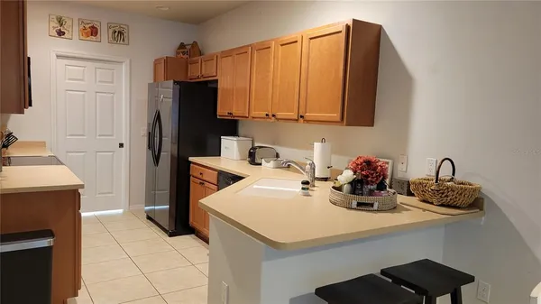 a kitchen with a sink a refrigerator and cabinets