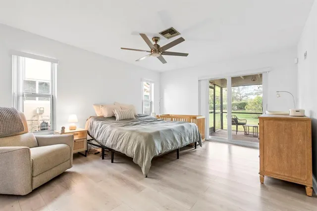 a spacious bedroom with a bed a couch and a large window