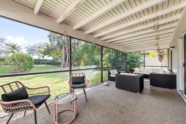 a living room with furniture and floor to ceiling windows