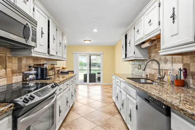 a kitchen with stainless steel appliances granite countertop a sink and stove