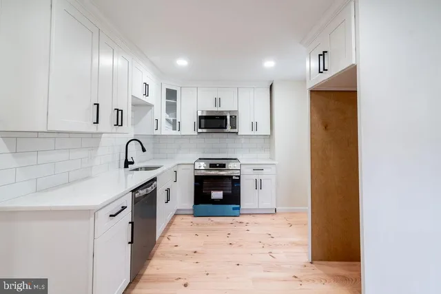 a kitchen with stainless steel appliances granite countertop a stove top oven a sink and a granite counter tops