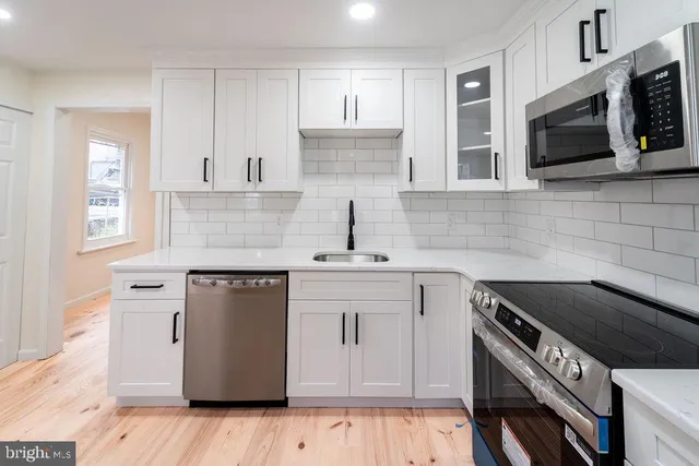 a kitchen with stainless steel appliances granite countertop a sink stove and microwave