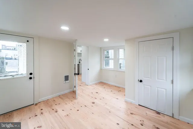 a view of a bedroom with wooden floor and window