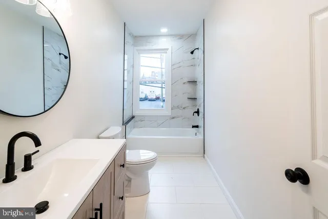 a bathroom with a sink a toilet and a mirror