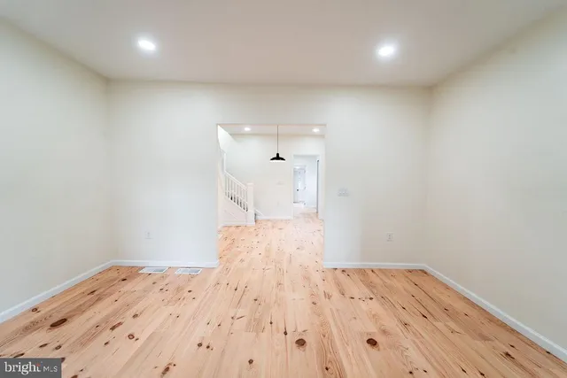 a view of a room with wooden floor and white walls