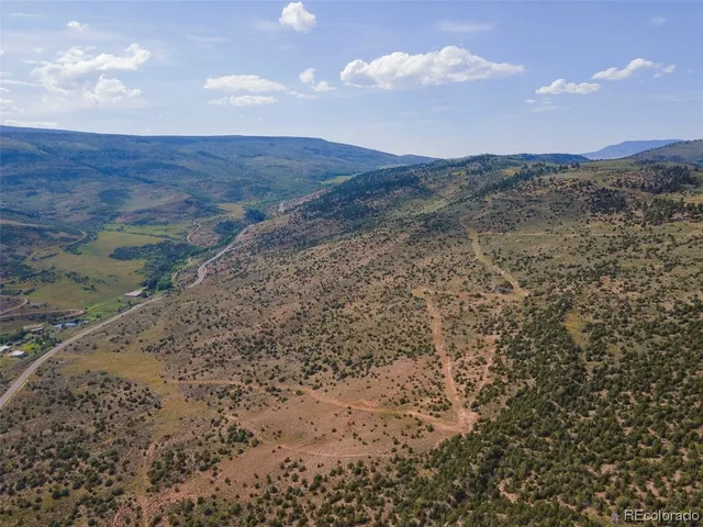 a view of a dry yard with mountains in the background