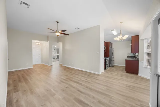 a view of a livingroom with a chandelier fan and a kitchen