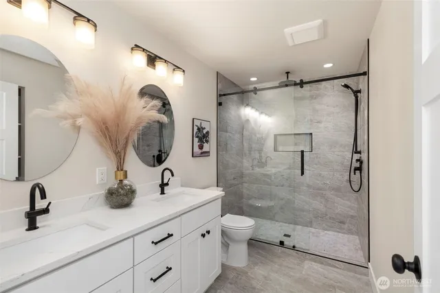 a bathroom with a double vanity sink mirror double shower and a mirror