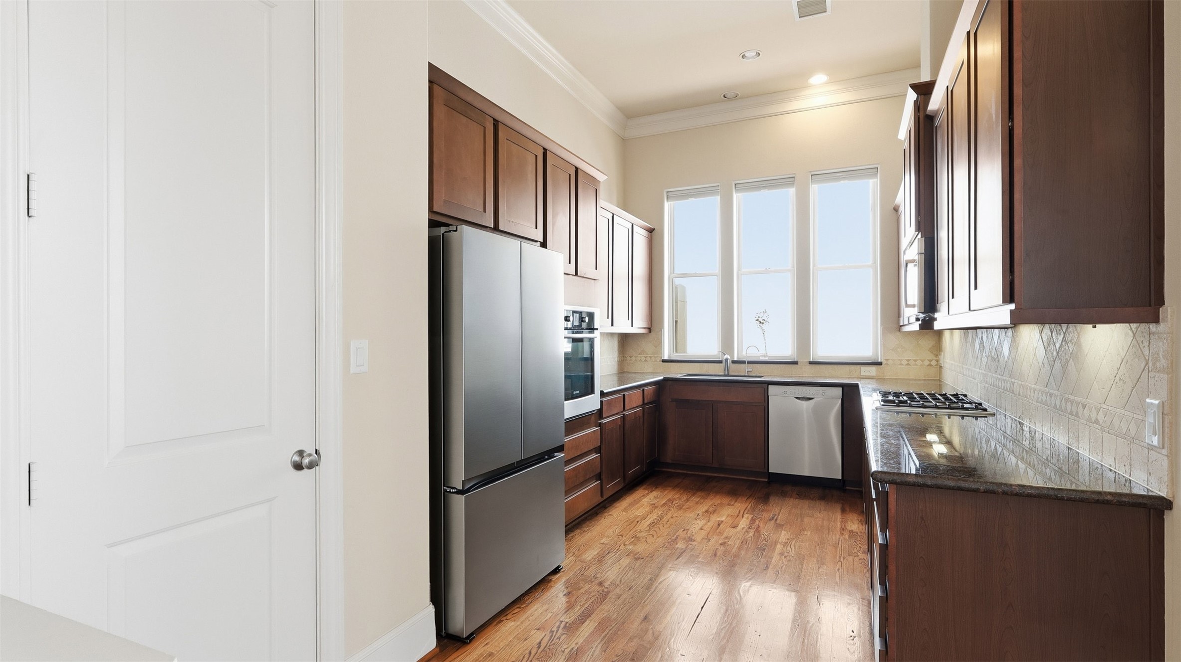 704 Paige Street Houston, TX 77003 - Photo 8 of 41 a kitchen with granite countertop a refrigerator and a sink