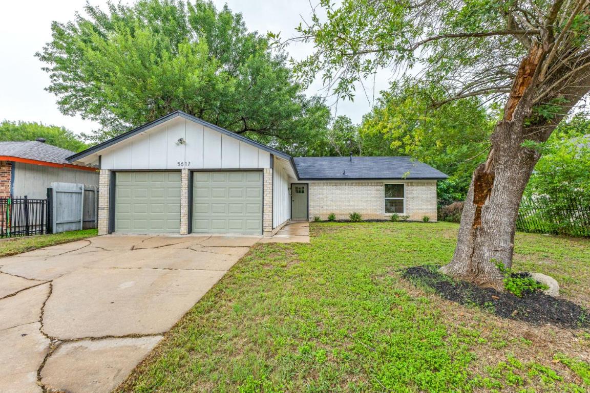 5617 Tallow Tree Drive Austin, TX 78744 - Photo 1 of 25 a front view of a house with a garden
