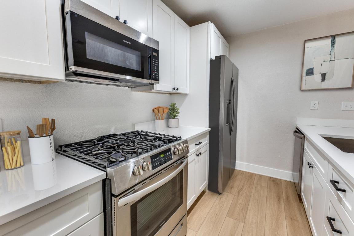 5617 Tallow Tree Drive Austin, TX 78744 - Photo 14 of 25 a kitchen with stainless steel appliances granite countertop a stove and a microwave