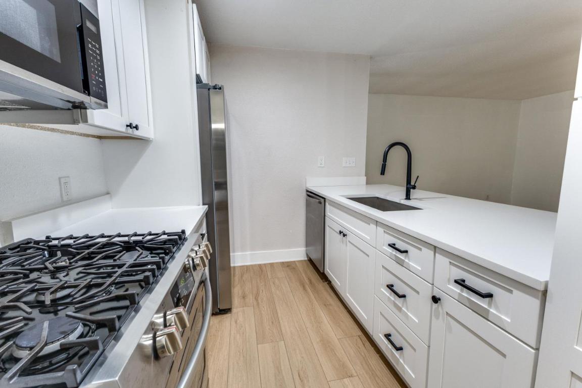 5617 Tallow Tree Drive Austin, TX 78744 - Photo 16 of 25 a kitchen with white cabinets and appliances
