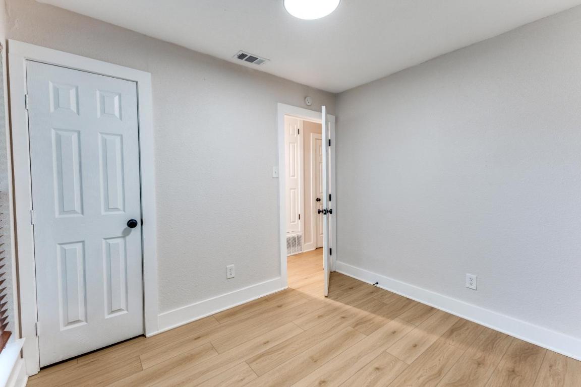 5617 Tallow Tree Drive Austin, TX 78744 - Photo 20 of 25 a view of an empty room with wooden floor