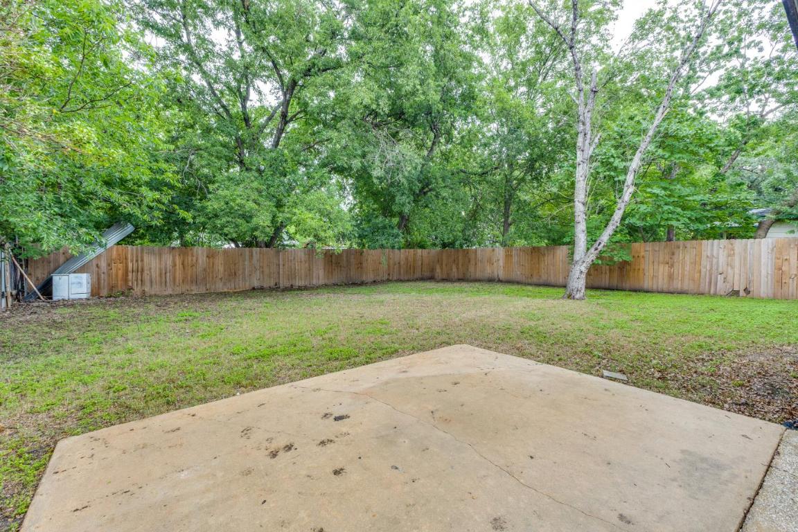 5617 Tallow Tree Drive Austin, TX 78744 - Photo 24 of 25 a view of a backyard with large trees and wooden fence