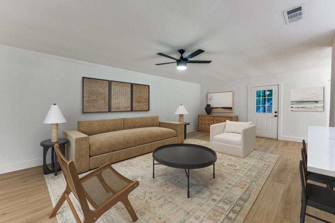 5617 Tallow Tree Drive Austin, TX 78744 - Photo 3 of 25 a living room with furniture a rug and a chandelier