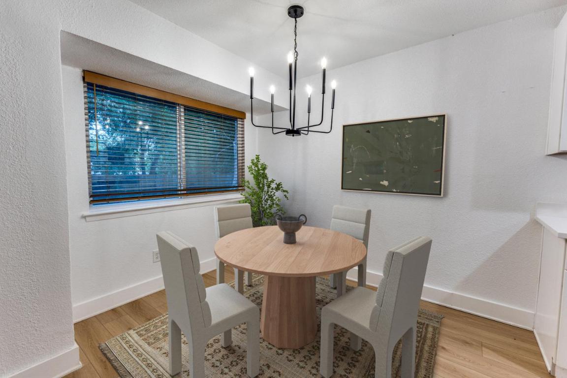 5617 Tallow Tree Drive Austin, TX 78744 - Photo 5 of 25 a dining room with furniture potted plants and wooden floor