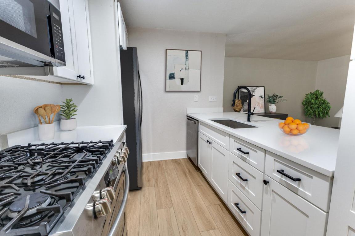 5617 Tallow Tree Drive Austin, TX 78744 - Photo 6 of 25 a kitchen with white cabinets and appliances