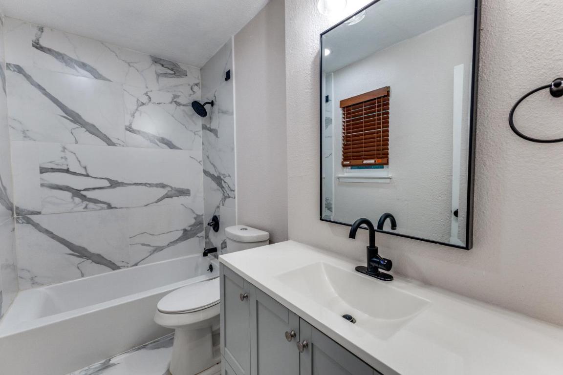 5617 Tallow Tree Drive Austin, TX 78744 - Photo 8 of 25 a bathroom with a sink a toilet and shower