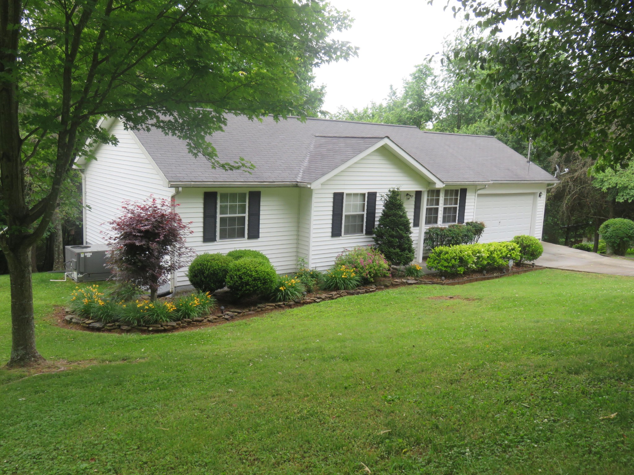 a front view of a house with a garden and plants