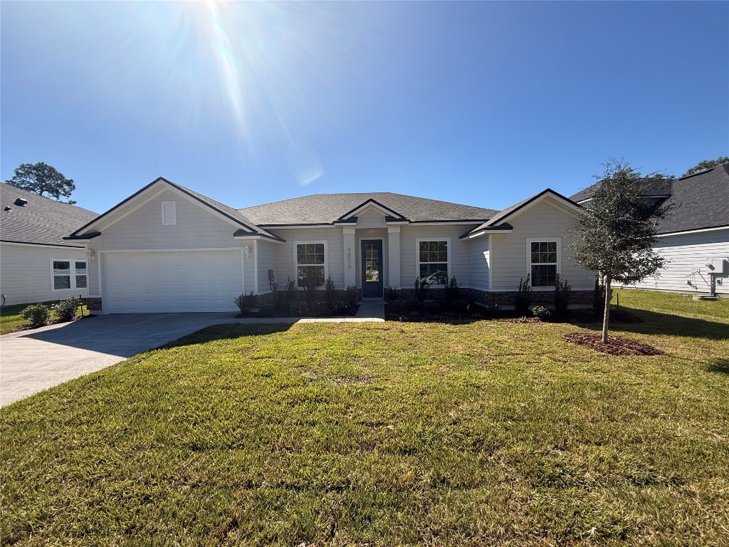96076 Pirates Bluff Road Yulee, FL 32097 - Photo 1 of 22 a view of a house with a yard and garage