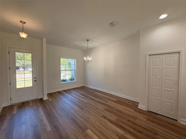 an empty room with wooden floor and window