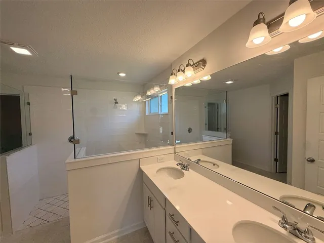 a bathroom with a sink double vanity granite and a mirror