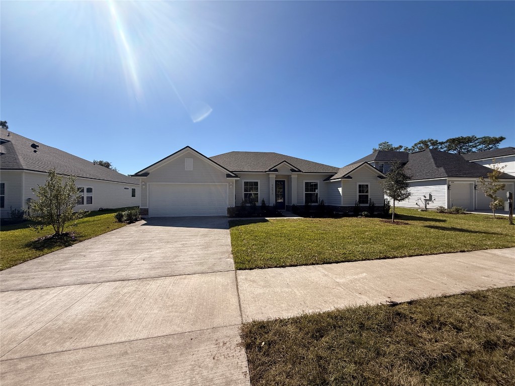 96076 Pirates Bluff Road Yulee, FL 32097 - Photo 2 of 22 a front view of a house with a yard and garage