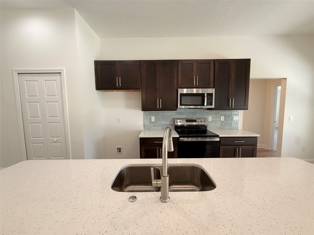 96076 Pirates Bluff Road Yulee, FL 32097 - Photo 6 of 22 a kitchen with a sink a microwave a refrigerator and cabinets