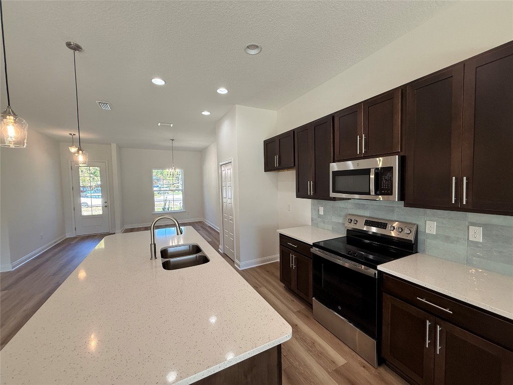 96076 Pirates Bluff Road Yulee, FL 32097 - Photo 7 of 22 a kitchen with stainless steel appliances a stove a sink a microwave a refrigerator and cabinets