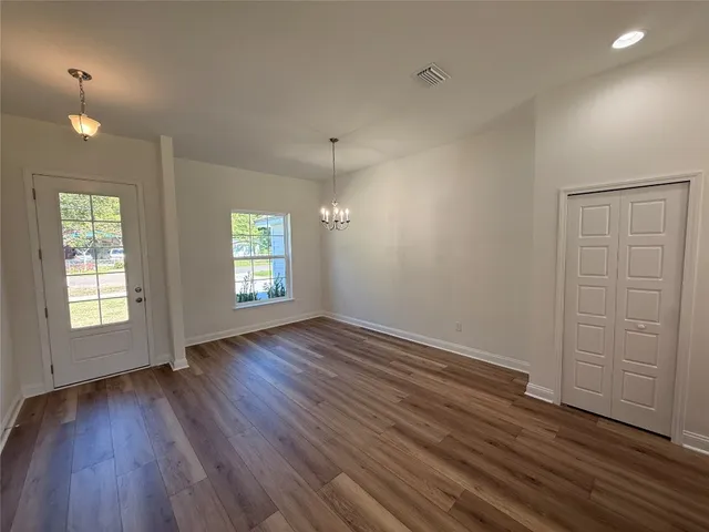 an empty room with wooden floor and window
