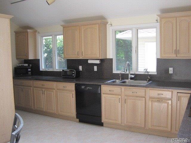 26 Ridge Drive East Roslyn, NY 11576 - Photo 16 of 28 a kitchen with white cabinets and a granite counter tops