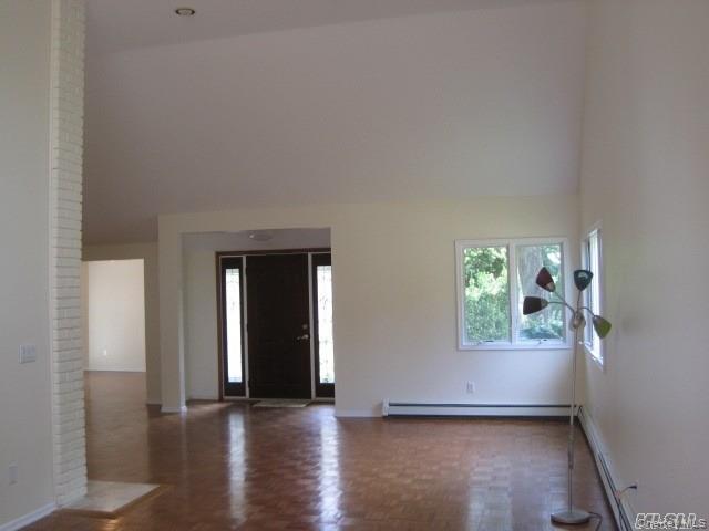 26 Ridge Drive East Roslyn, NY 11576 - Photo 10 of 28 an empty room with window and wooden floor