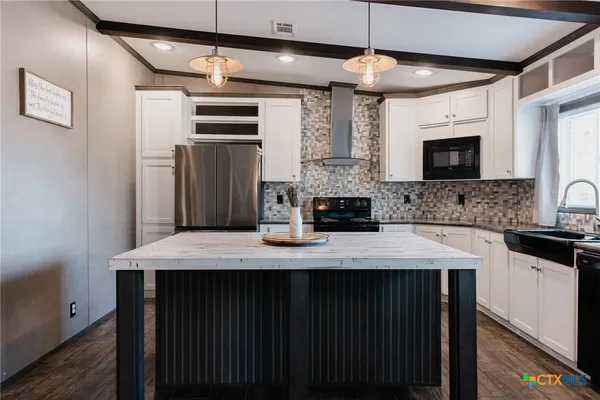 a kitchen with kitchen island a sink stainless steel appliances and cabinets