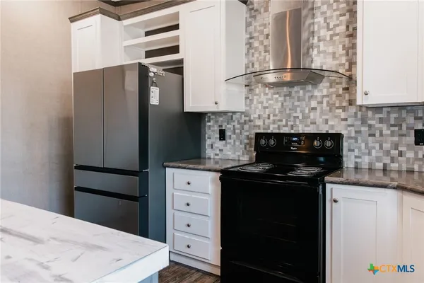 a kitchen with a refrigerator and a stove top oven