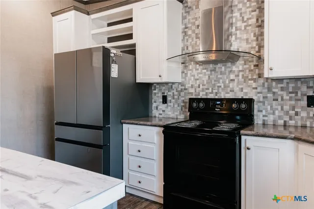 a kitchen with a refrigerator and a stove top oven