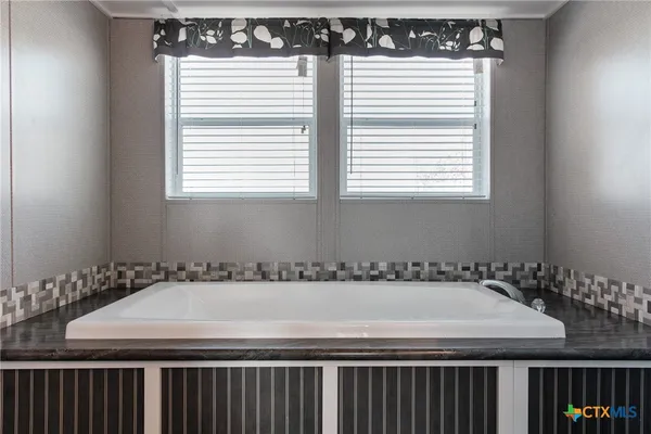 a room with a table a window and a white cabinets