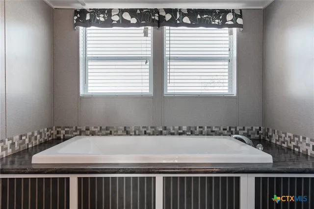 a room with a table a window and a white cabinets
