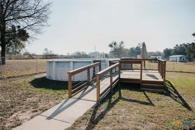 a view of a lake with wooden stairs and bench next to a lake