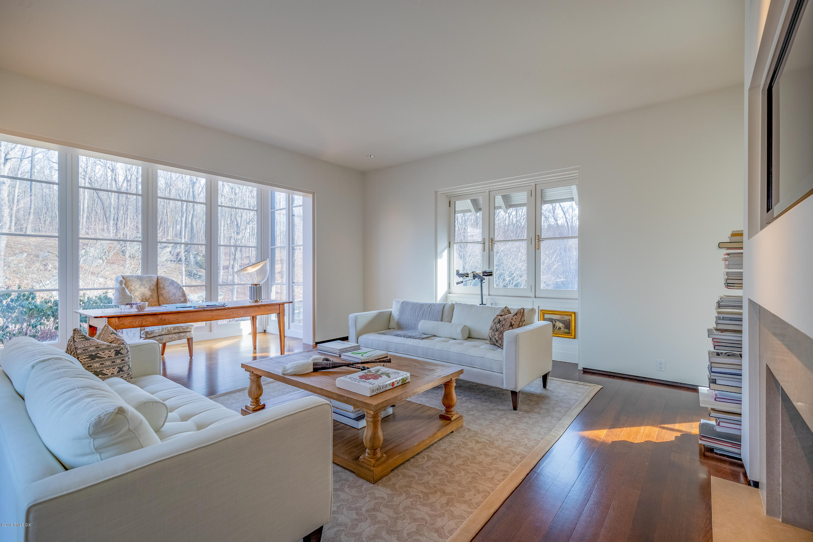 373 Riverbank Road Stamford, CT 06903 - Photo 12 of 35 a living room with furniture a fireplace and large windows