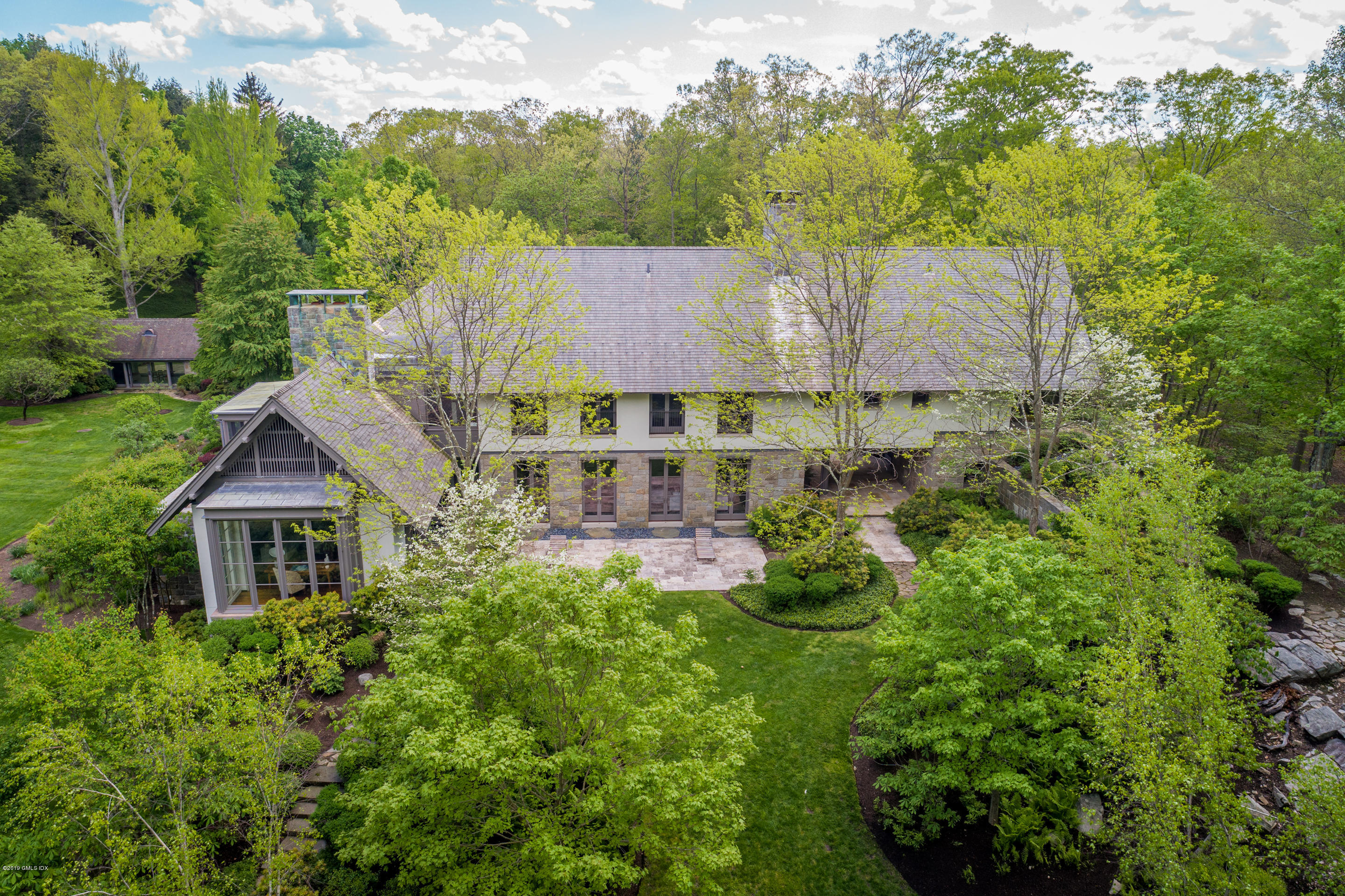 373 Riverbank Road Stamford, CT 06903 - Photo 19 of 35 a aerial view of a house with yard and trees in the background