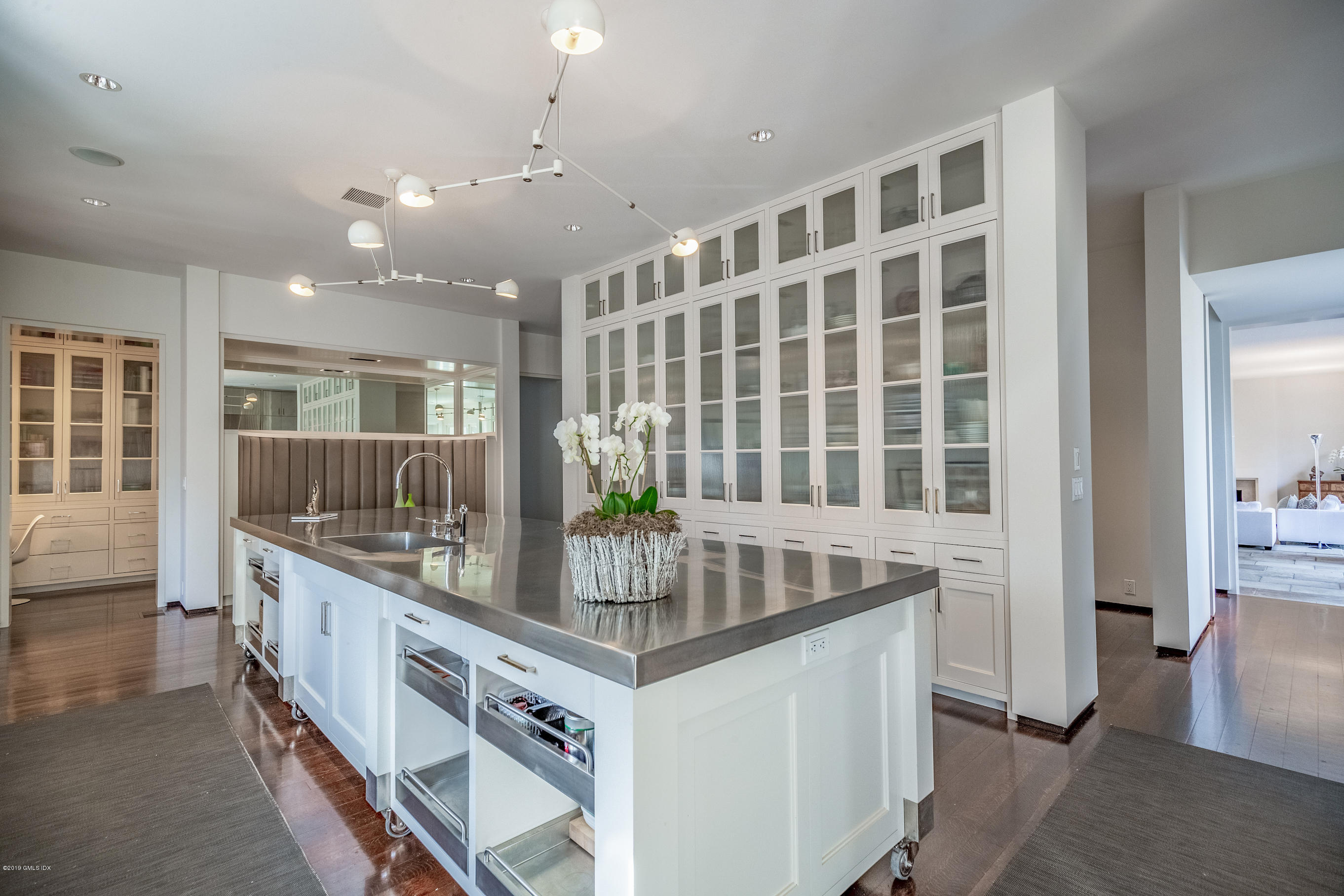 373 Riverbank Road Stamford, CT 06903 - Photo 5 of 35 a kitchen that has a lot of white cabinets and a wooden floor